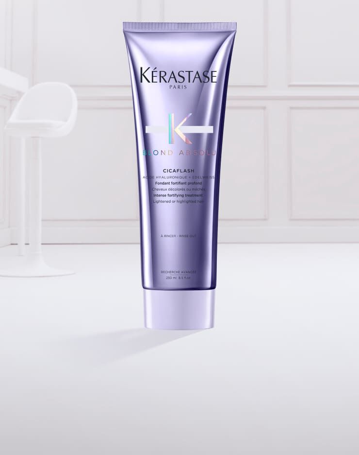 Tube de masque capillaire Kerastase Blonde Absolu Cicaplasth sur fond clair, avec une texture cremeuse en sortie du tube.