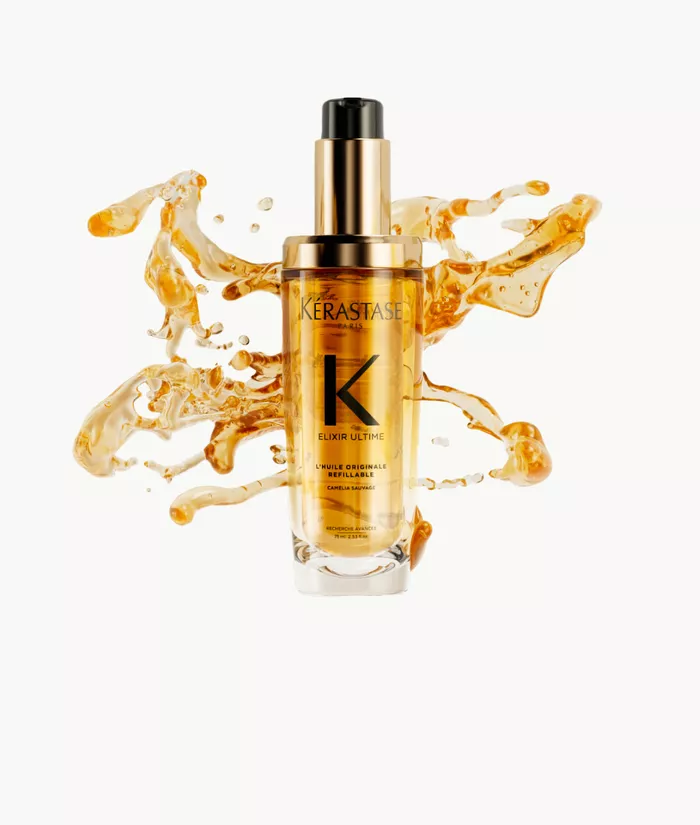Flacon de serum Kerastase Elixir Ultime, entoure de gouttes d'huile doree sur fond clair.