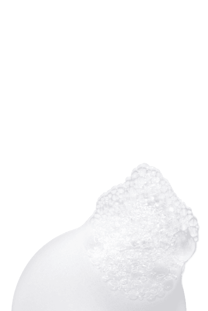 Gros plan d'une texture cremeuse blanche et riche, illustrant un produit capillaire nourrissant.