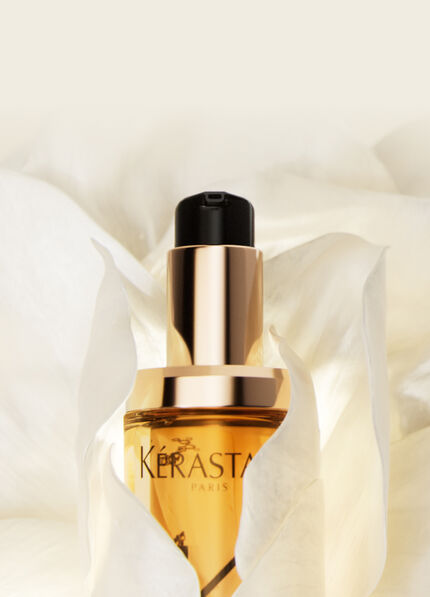 Flacon d'un serum, pose sur un petale de fleur blanche, avec un fond doux et clair.