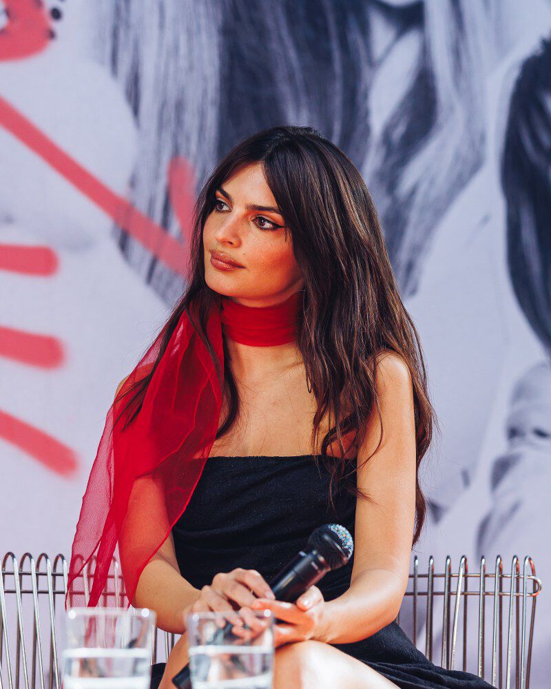 Emily Ratajkowski egerie Kerastase dans un decor colore : bleu et rouge - attentive a la discussion