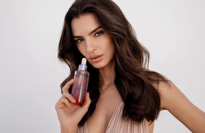 Flacon de serum Kerastase a cote d'une rose rouge, illustrant l'ancrage et la fixation des cheveux a la racine