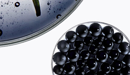 Trois capsules de forme et de couleurs differentes, dont une est blanche, une est noire a billes et une montre un liquide vert fonce, sur un fond clair.