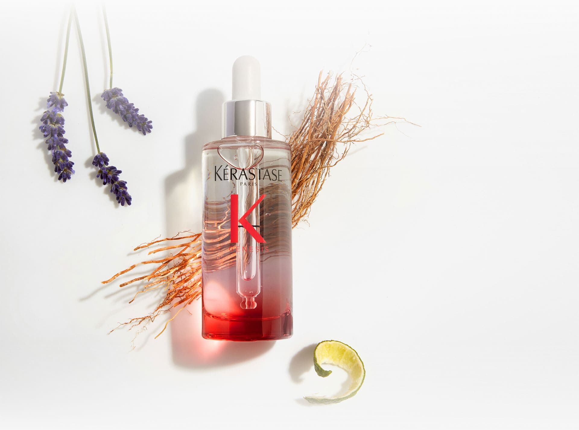 Flacon de serum Kerastase Genesis Serum Anti-Chute Fortifiant, entoure d'elements botaniques comme la lavande et le gingembre.