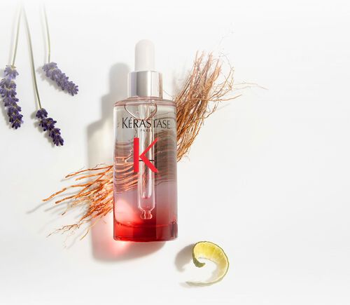 Flacon de serum Kerastase Genesis Serum Anti-Chute Fortifiant, entoure d'elements botaniques comme la lavande et le gingembre.