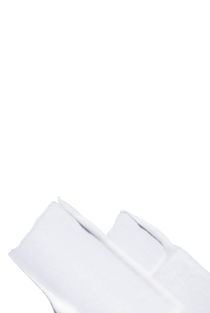 Gros plan d'une texture cremeuse blanche et riche, illustrant un produit capillaire nourrissant.