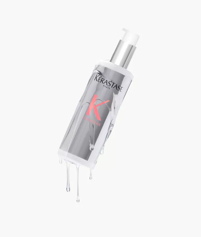 Flacon de serum capillaire Kerastase, transparent, avec des gouttes d'eau qui s'ecoulent.