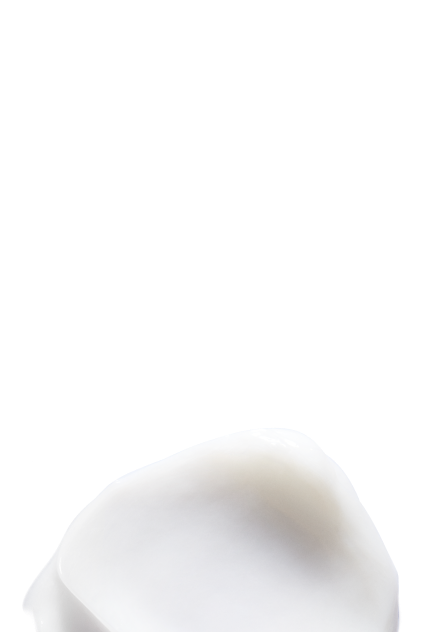 Gros plan d'une texture cremeuse blanche et riche, illustrant un produit capillaire nourrissant.
