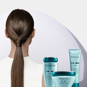 Femme avec une queue de cheval brillante et des produits Kerastase Resistance turquoise.