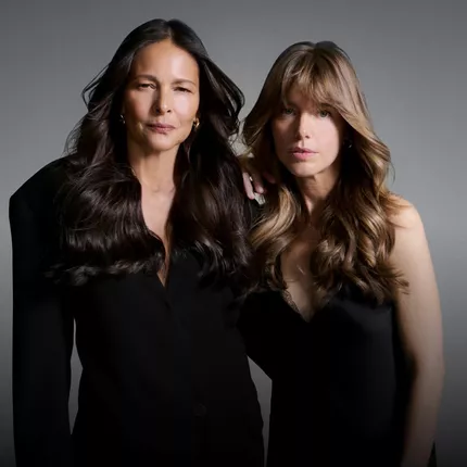 Deux femmes de generations differentes vetues de noir, illustrant les habitudes pour conserver des cheveux sains avec le temps