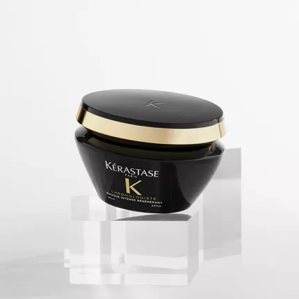 Un pot de creme capillaire Kerastase Chronologiste sur un fond blanc, pose sur des blocs de verre transparent.