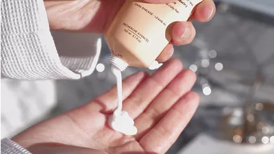 Mains tenant delicatement des meches de cheveux boucles pour les revitaliser entre les lavages