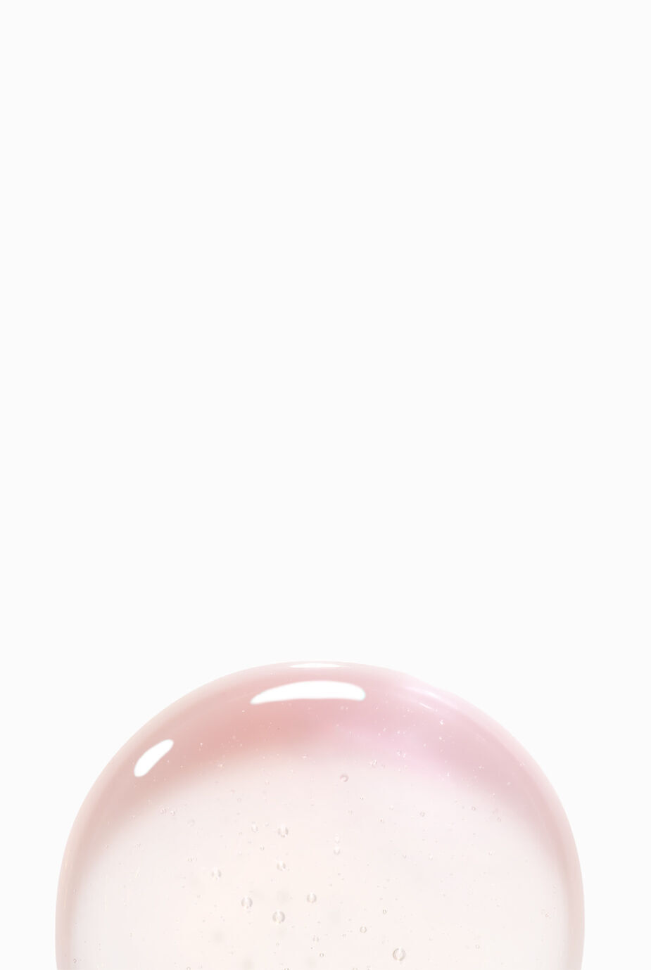 Bulle rose irisee sur un fond blanc.