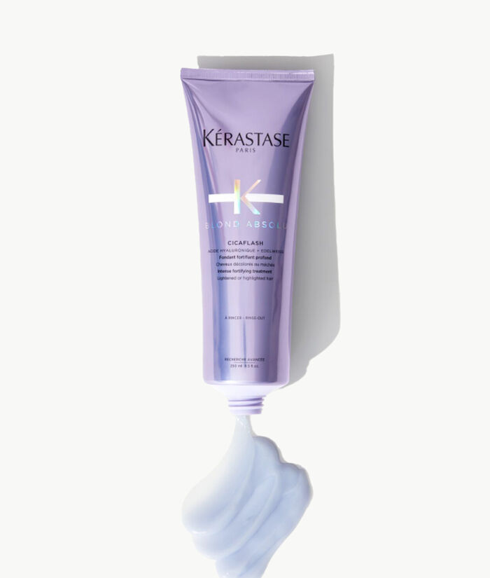 Tube de masque capillaire Kerastase Blonde Absolu Cicaplasth sur fond clair, avec une texture cremeuse en sortie du tube.