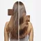 Model shows her shiny healthy dark hair after using Elixir Ultime hair oil.