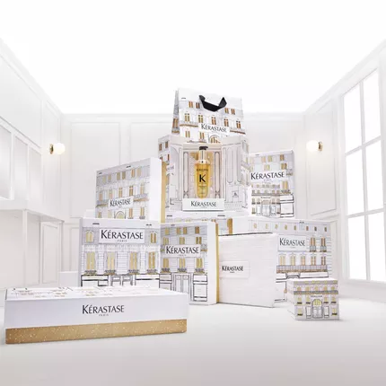 Empilement decoratif de coffrets et packagings Kerastase blancs et dores, de la gamme Elixir Ultime.
