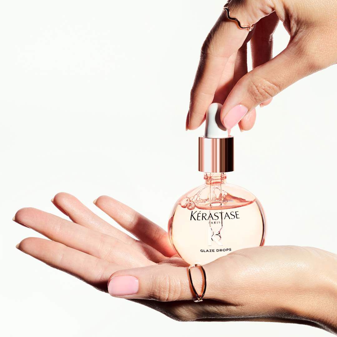 L'huile Glaze Drops Gloss Absolu Kerastase posee dans une main.