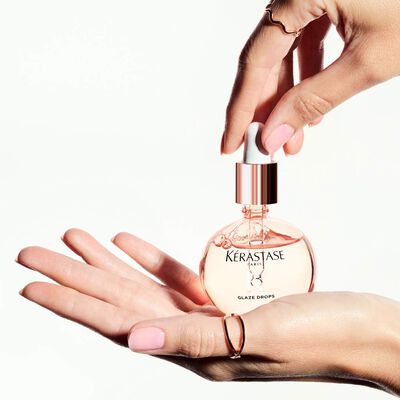L'huile Glaze Drops Gloss Absolu Kerastase posee dans une main.