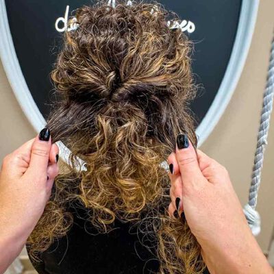 Rassemblez le reste des cheveux et realisez une seconde attache en reproduisant la meme technique de twist afin de conserver le mouvement naturel des boucles