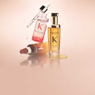 Le Serum Magic 8h Nutritive & Le serum Anti-chute Fortifiant Genesis de Kerastase, flottant sur un fond degrade orange.​