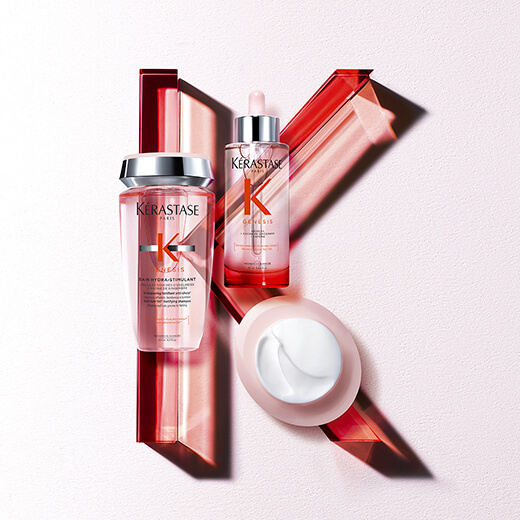Produits de soin capillaire Kérastase avec flacon, sérum et crème sur fond minimaliste, en rouge et rose.