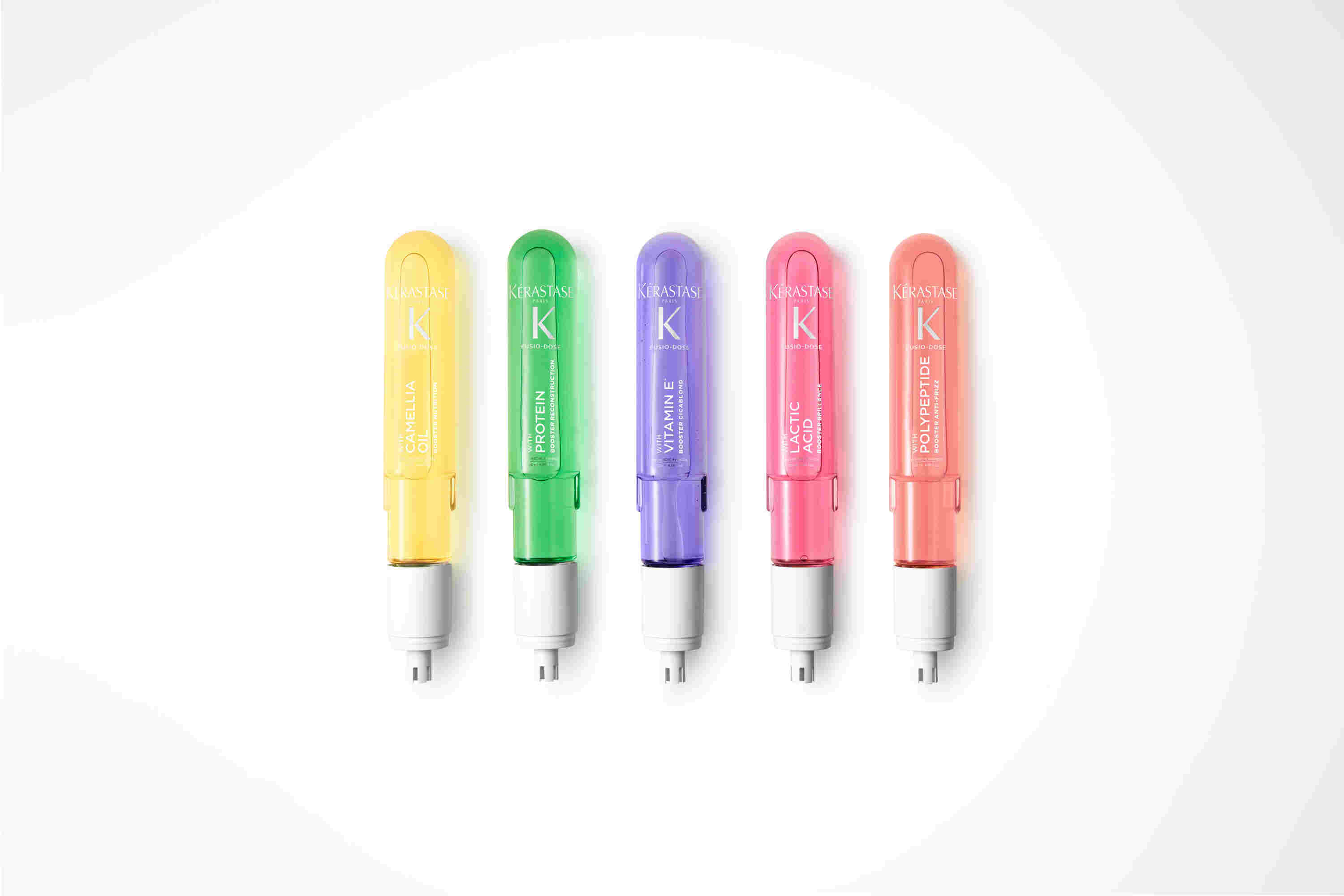 Gamme de produits capillaires Kérastase : cinq flacons colorés pour différents traitements des cheveux sur fond blanc.